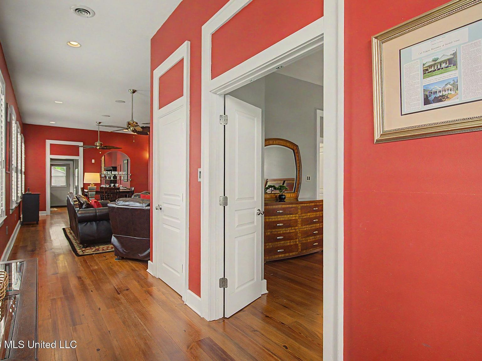 Shotgun-style interior hallway with heart pine flooring and high ceilings