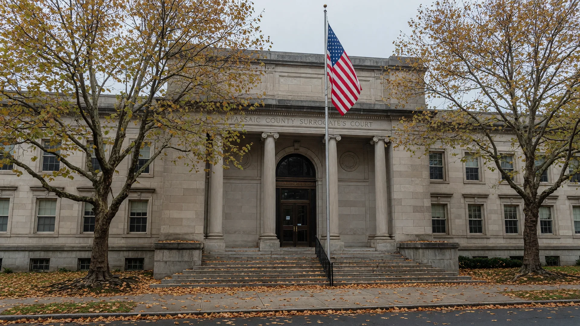 Passaic County Surrogate's Court building in Paterson, New Jersey on an overcast morning with autumn leaves