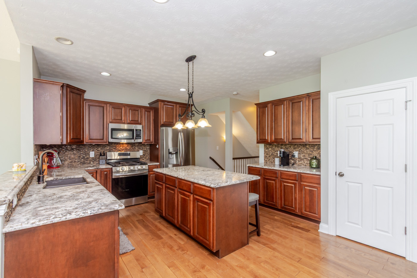 Kitchen island with granite countertops and cherry cabinetry