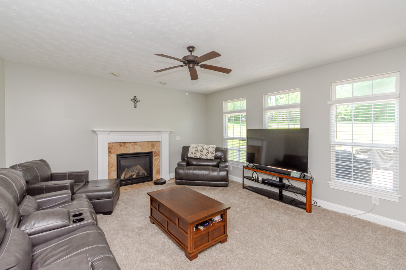 Family room with stone-surround fireplace and wood mantel