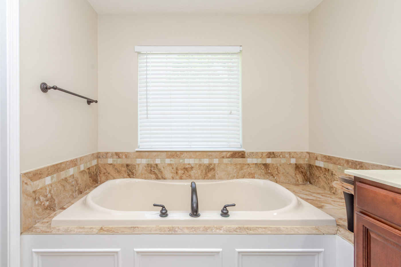 Garden tub in primary bathroom with tile surround