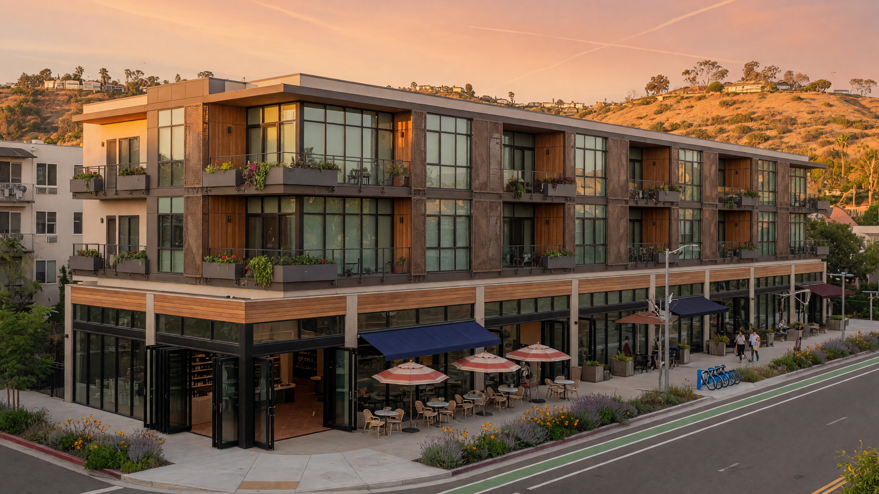 Modern mixed-use development in San Diego with retail storefronts and apartments above, photographed during golden hour
