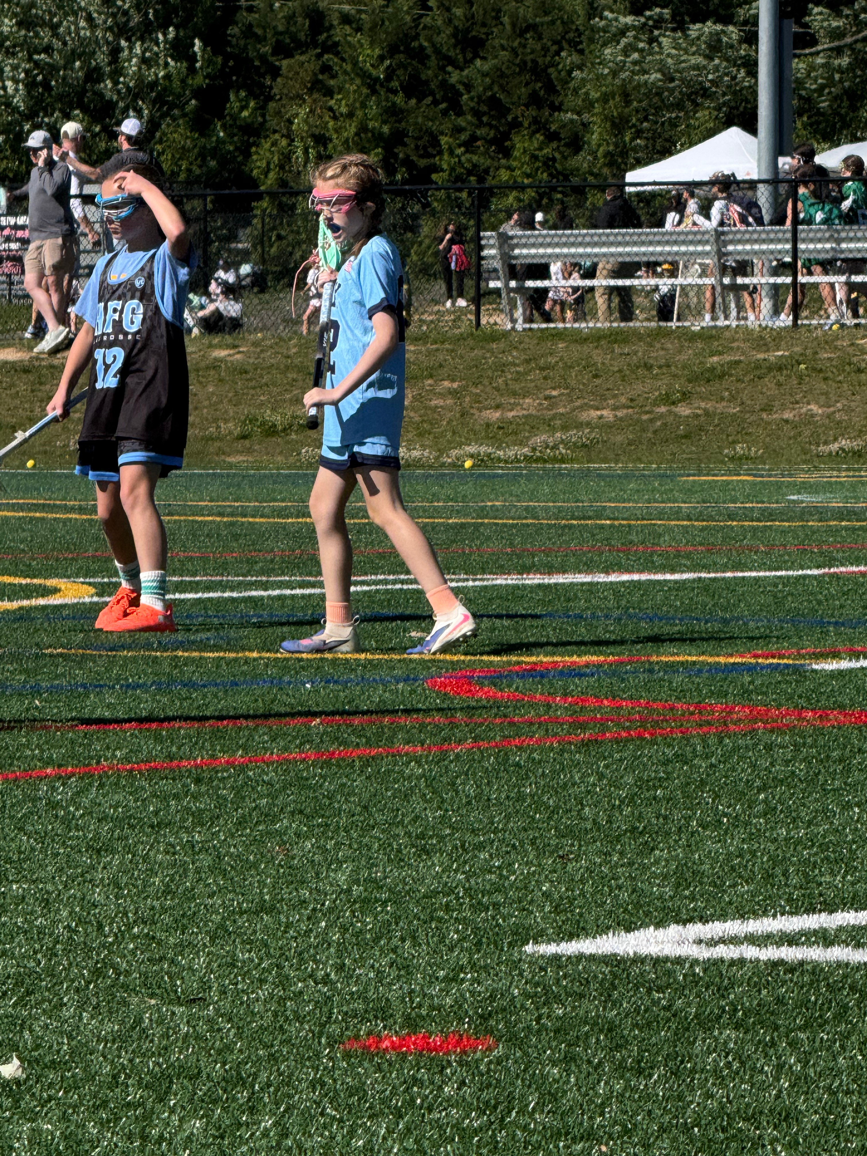 Girls playing lacrosse on a turf field