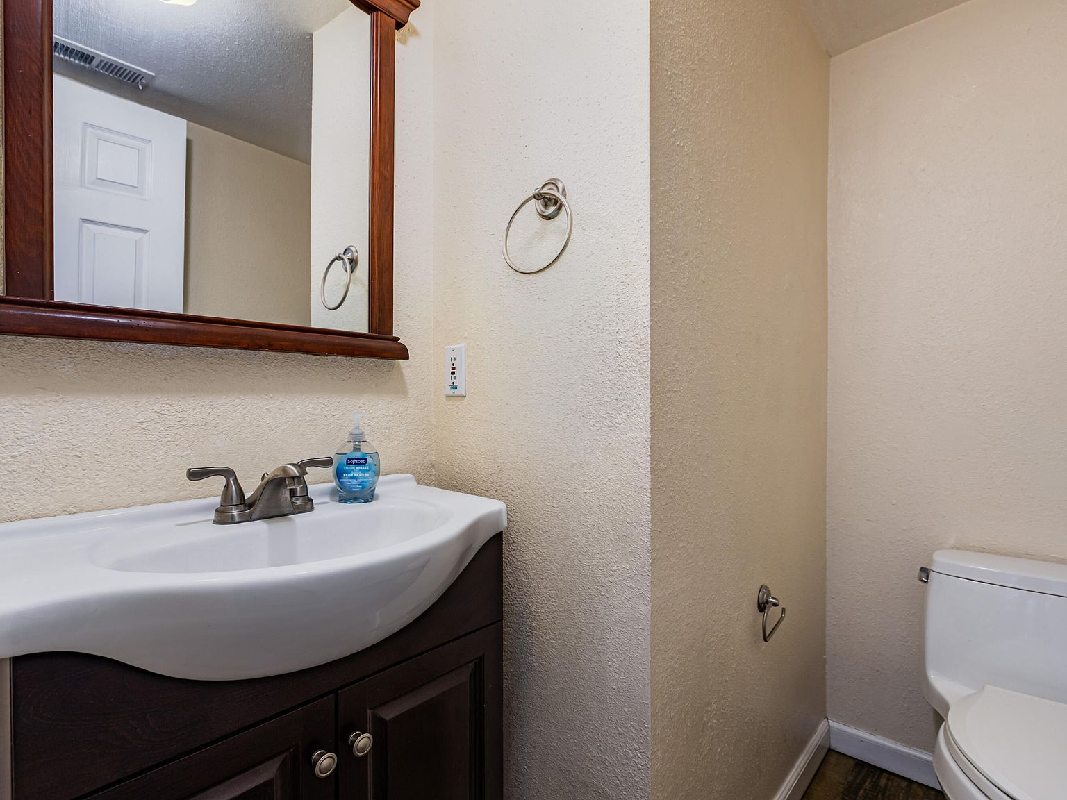 Half bathroom with dark wood vanity