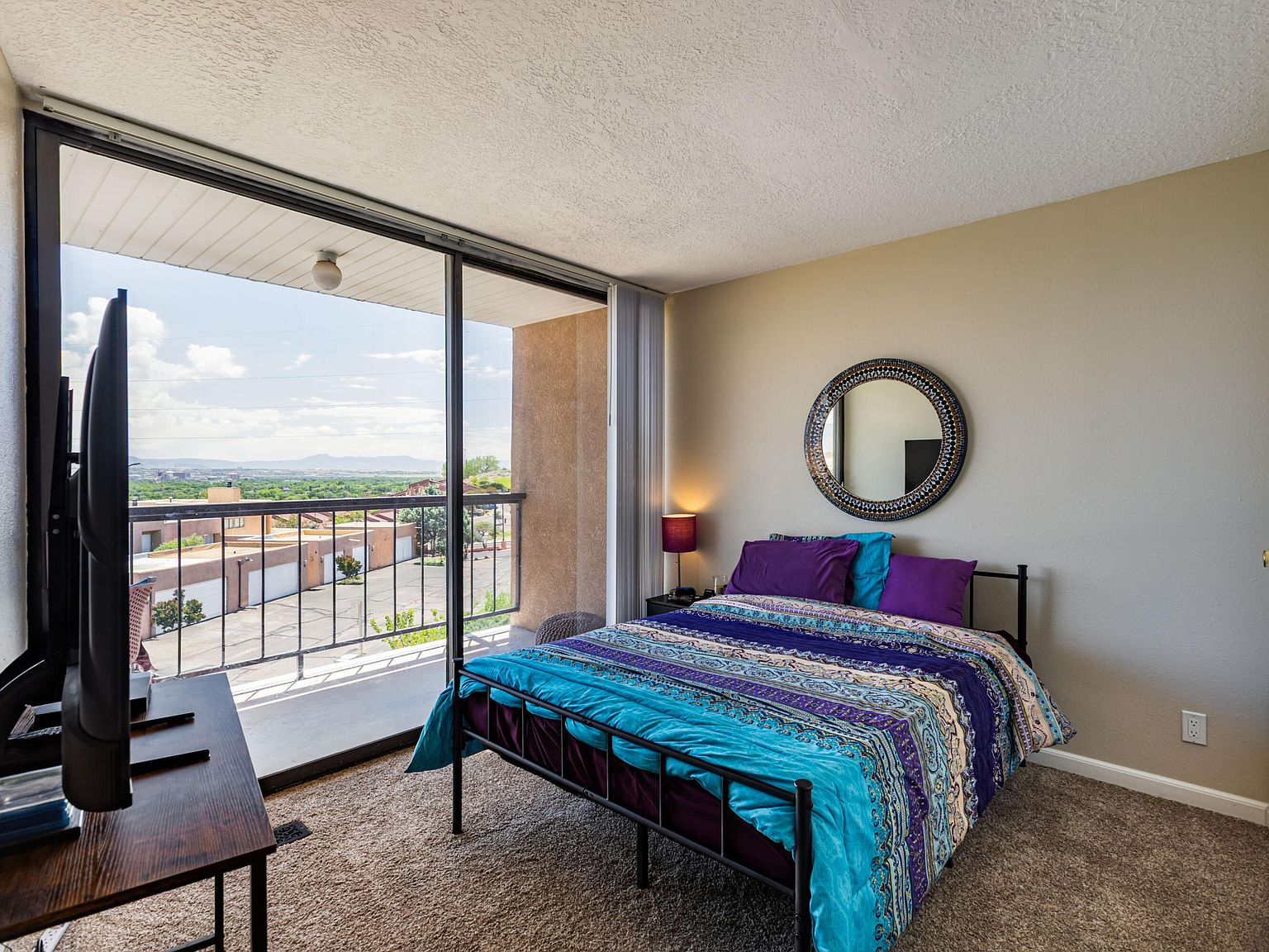 Bedroom with balcony access and natural daylight