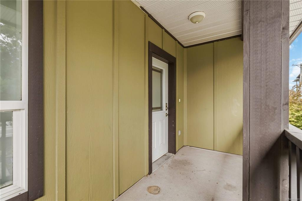 Covered front entry porch with earth-tone green siding