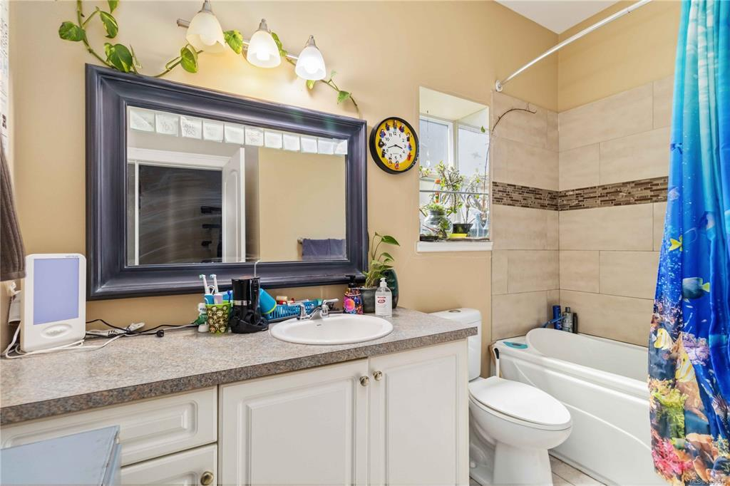 Bathroom vanity with white cabinetry and tiled shower surround