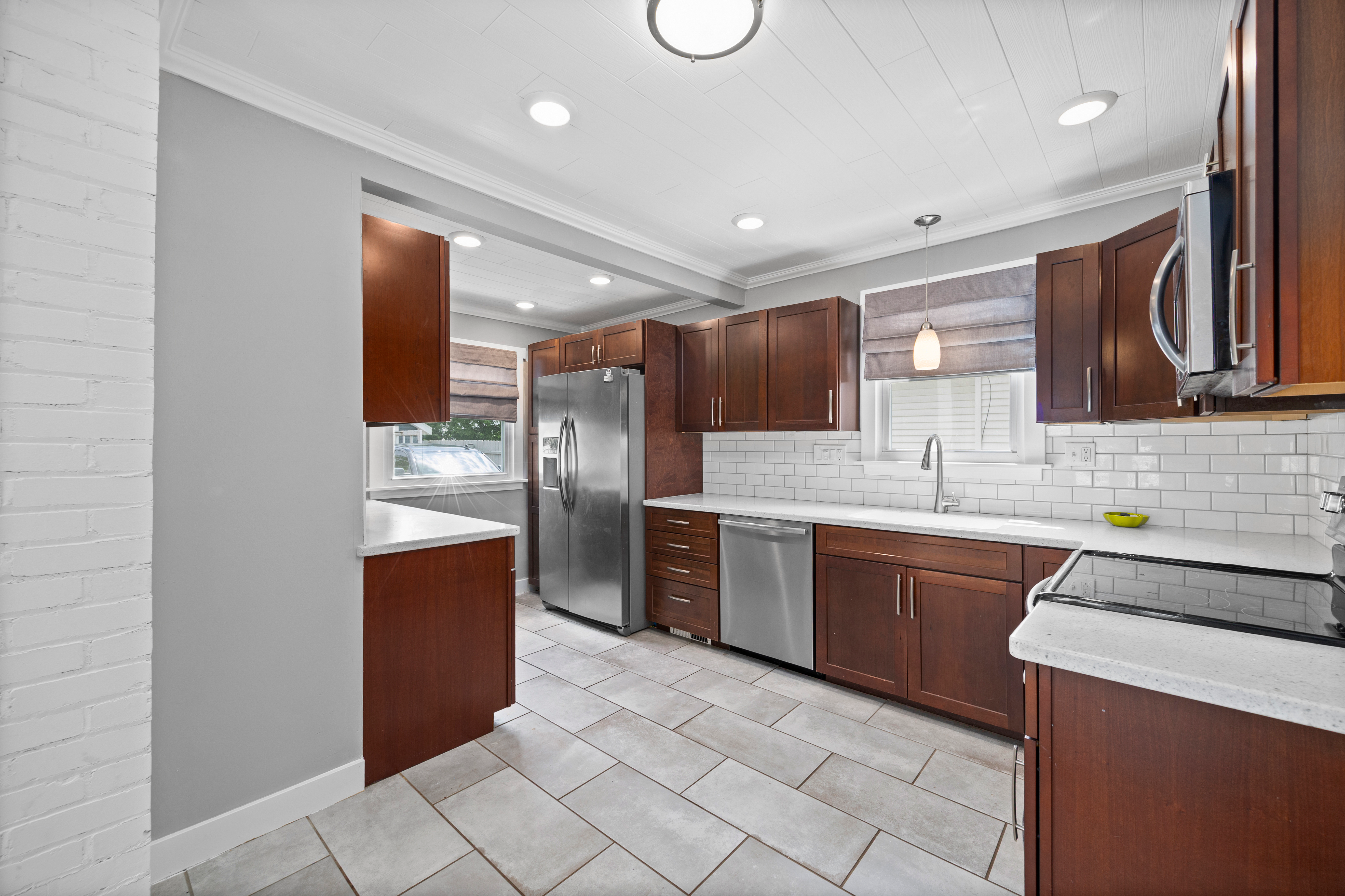 Kitchen perspective showing wood cabinetry and stainless appliances