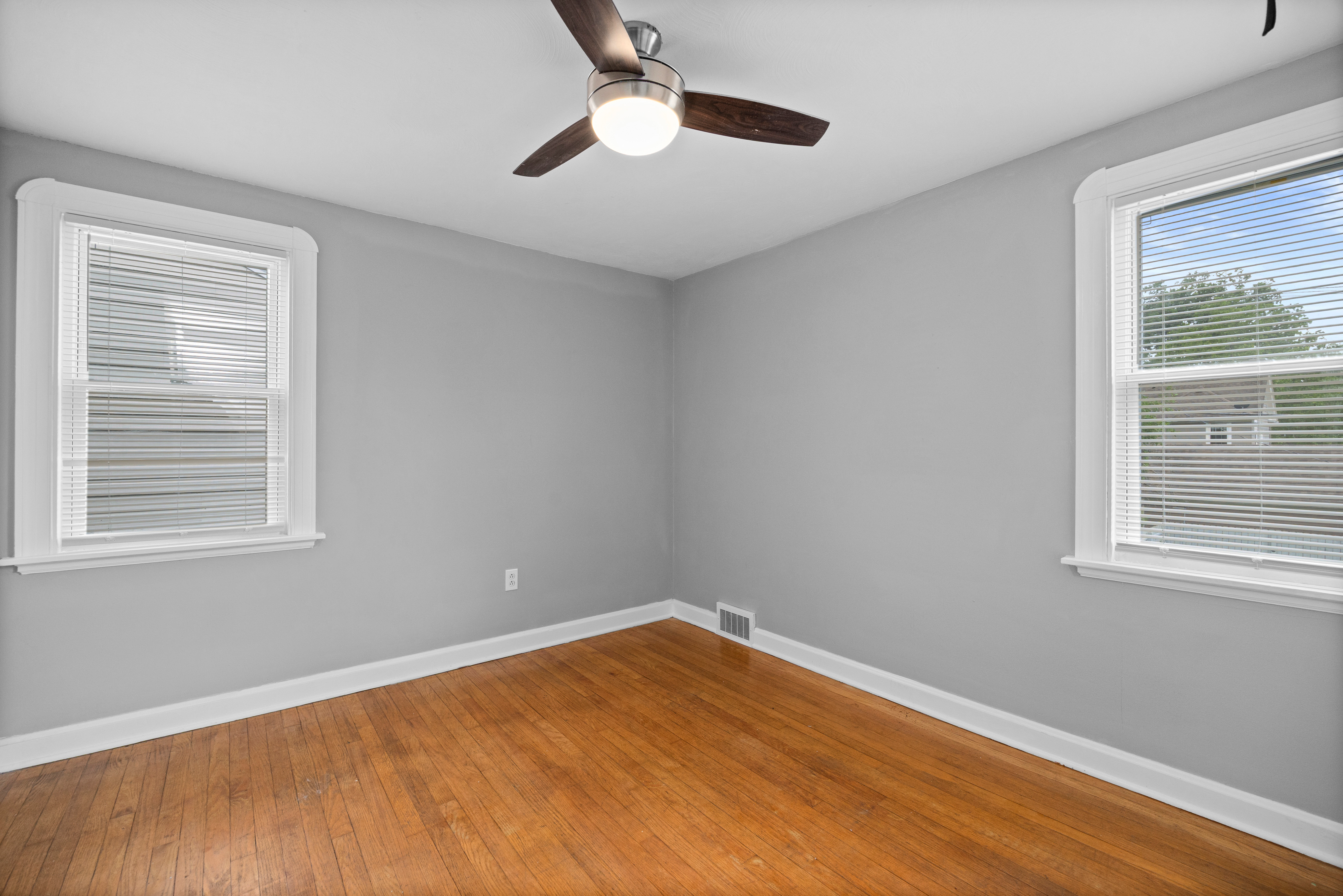 Upper-level bedroom with hardwood floors and natural light