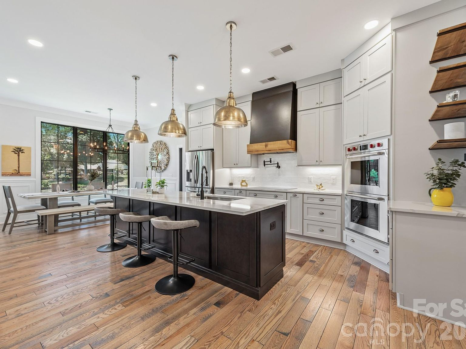 Kitchen with two-tone cabinetry, stainless steel appliances, and wood flooring