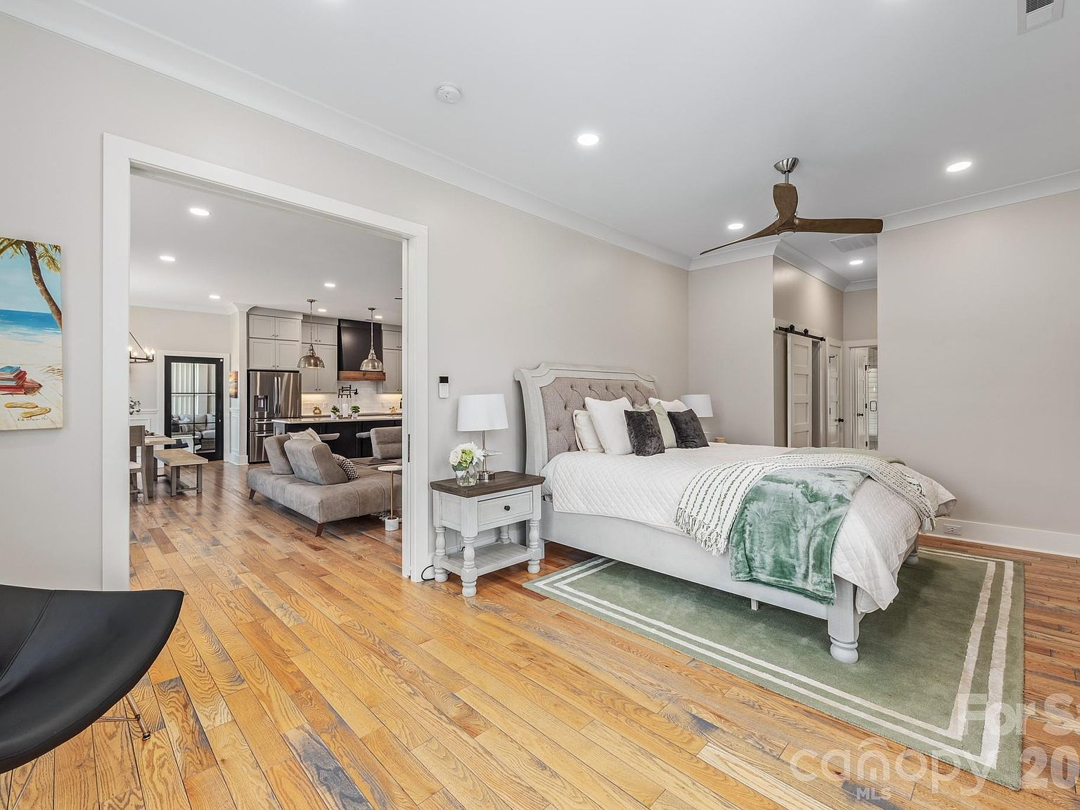 Main-level primary suite with wood flooring and open-concept layout