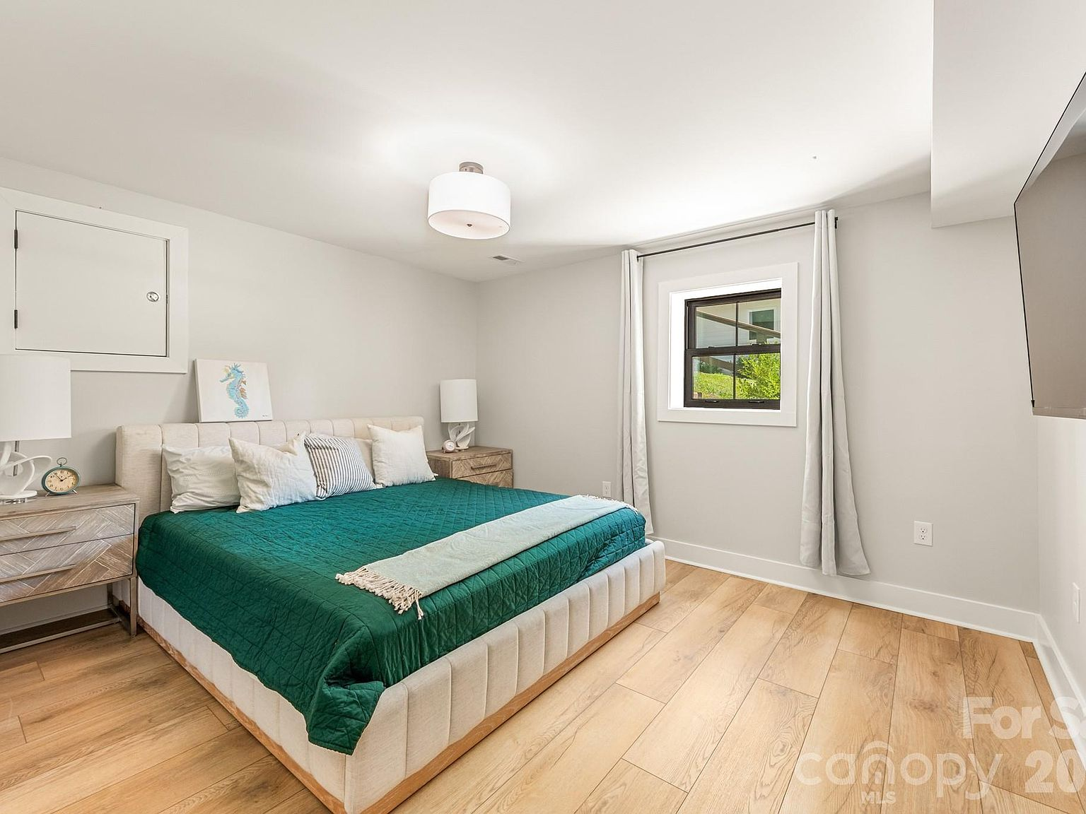 Secondary bedroom with light walls and hardwood floors