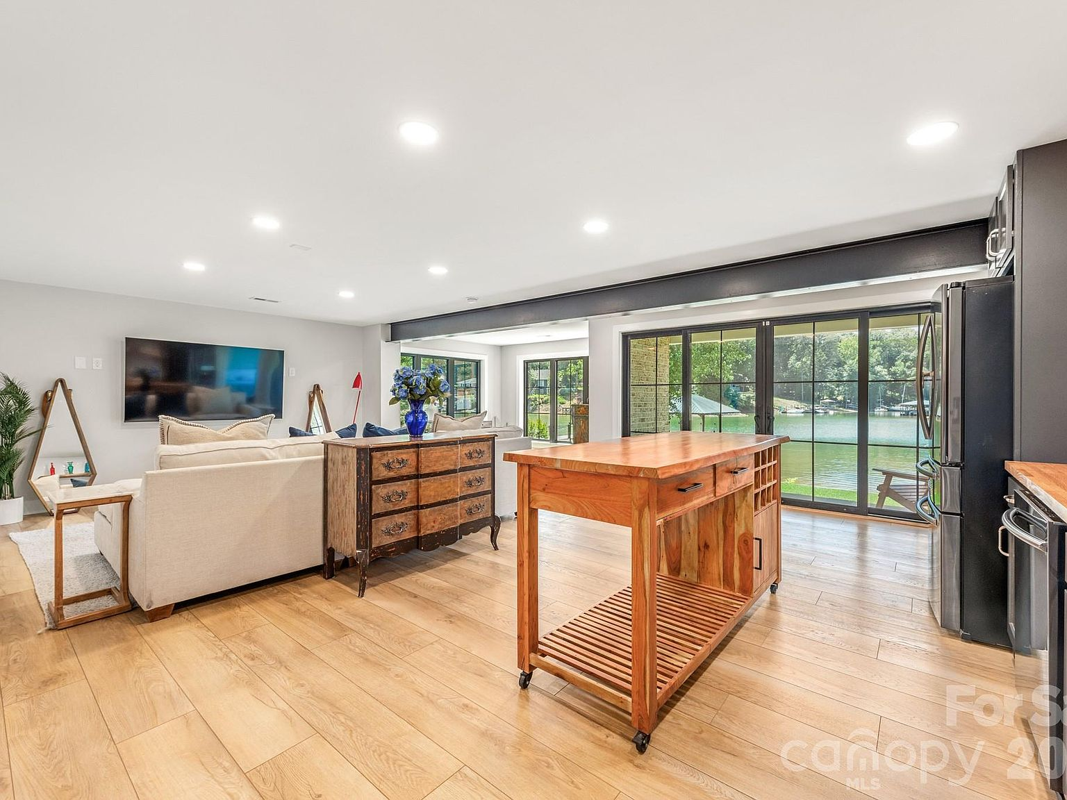 Living and kitchen area with large sliding glass doors overlooking the lake