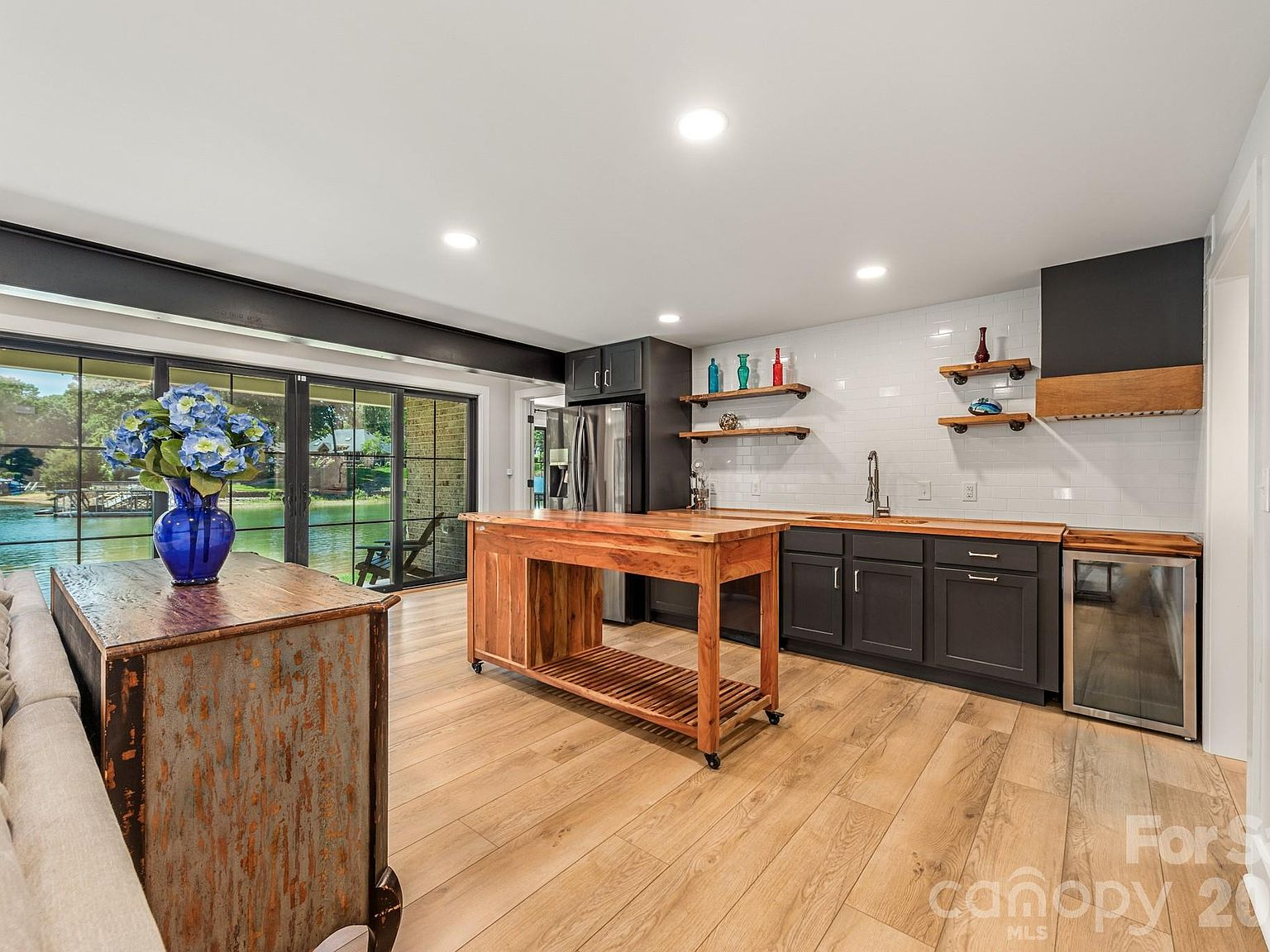 Kitchen with butcher-block countertops and waterfront views through glass doors