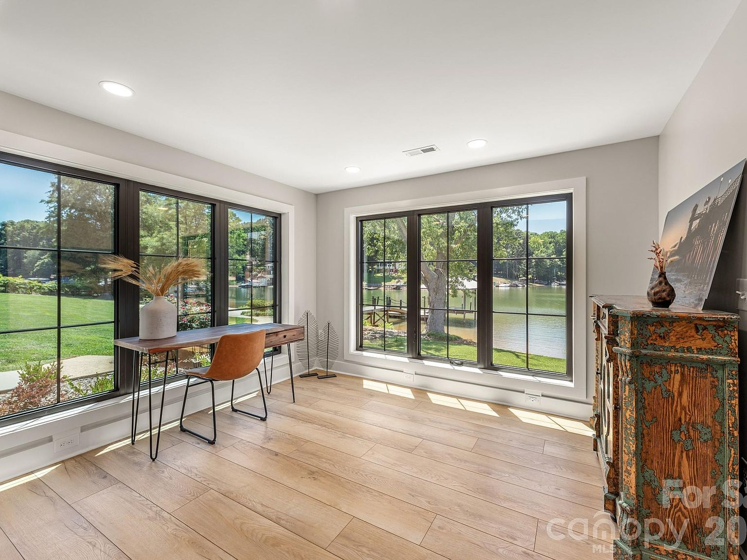 Flex space or office with extensive lake vistas through dark-framed grid windows