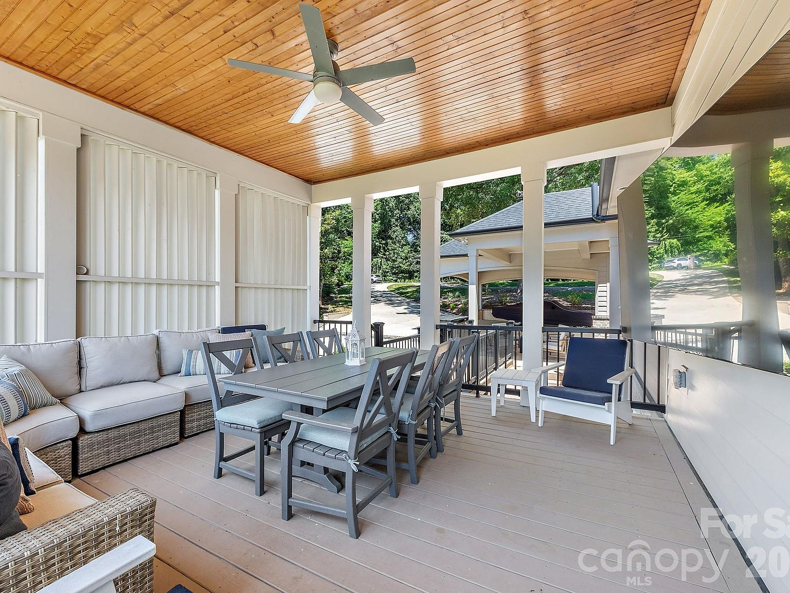 Covered deck with wood-planked ceiling and outdoor dining