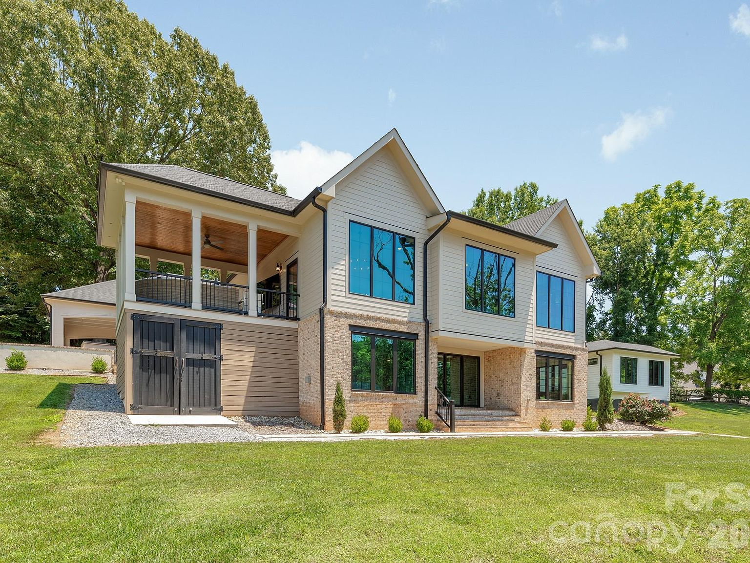 Rear view of the waterfront home with covered deck