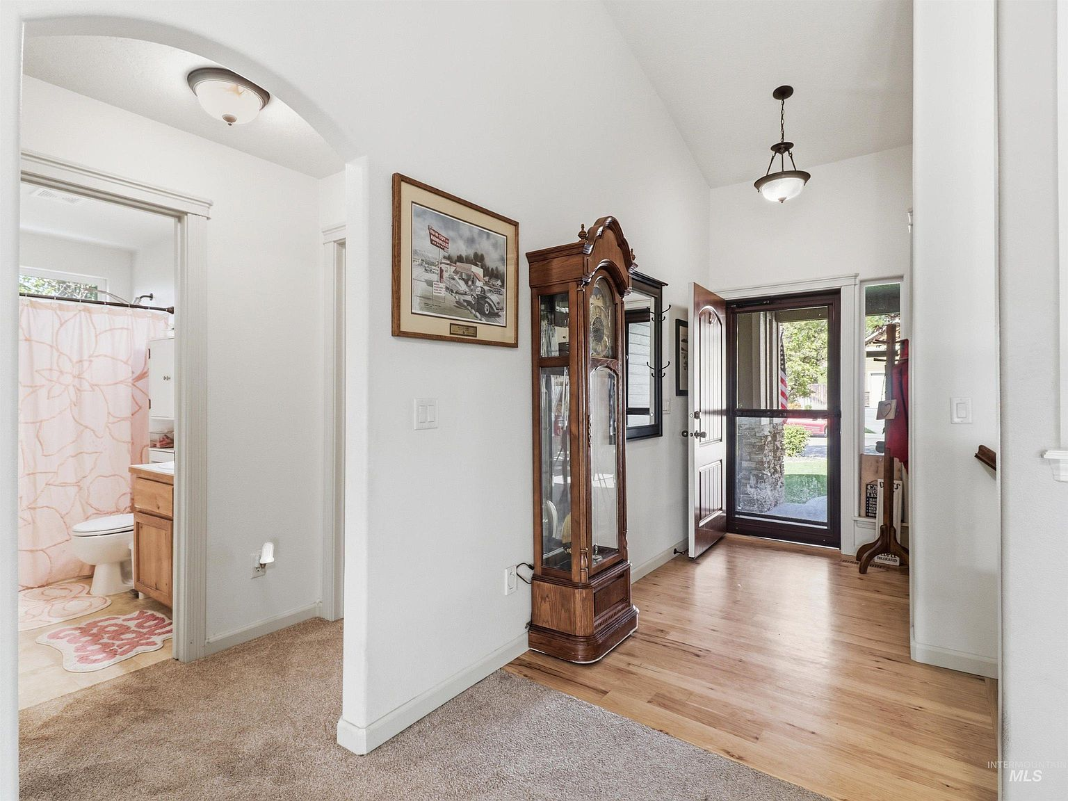Bright front entryway with hardwood flooring