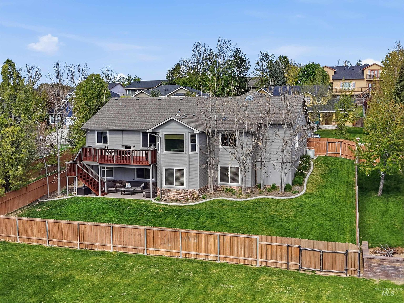 Rear deck with tiered patio and expansive lawn