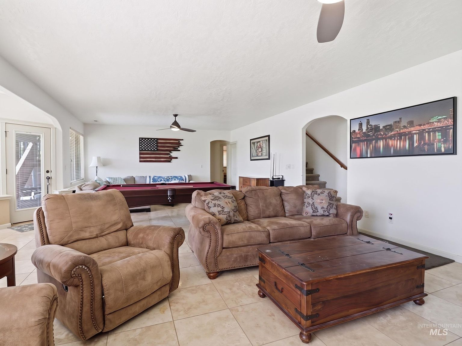 Open-concept basement with travertine tile