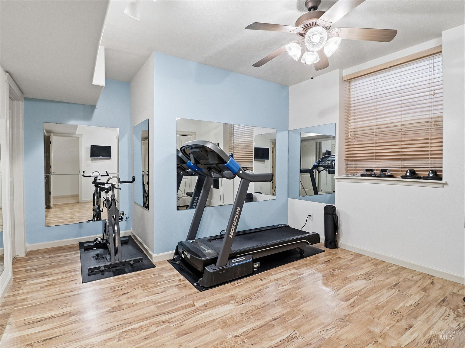 Dedicated fitness room with light wood flooring
