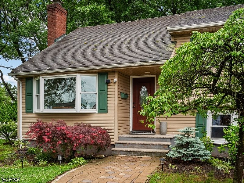 Front entrance with red door, Japanese maple, and stone walkway