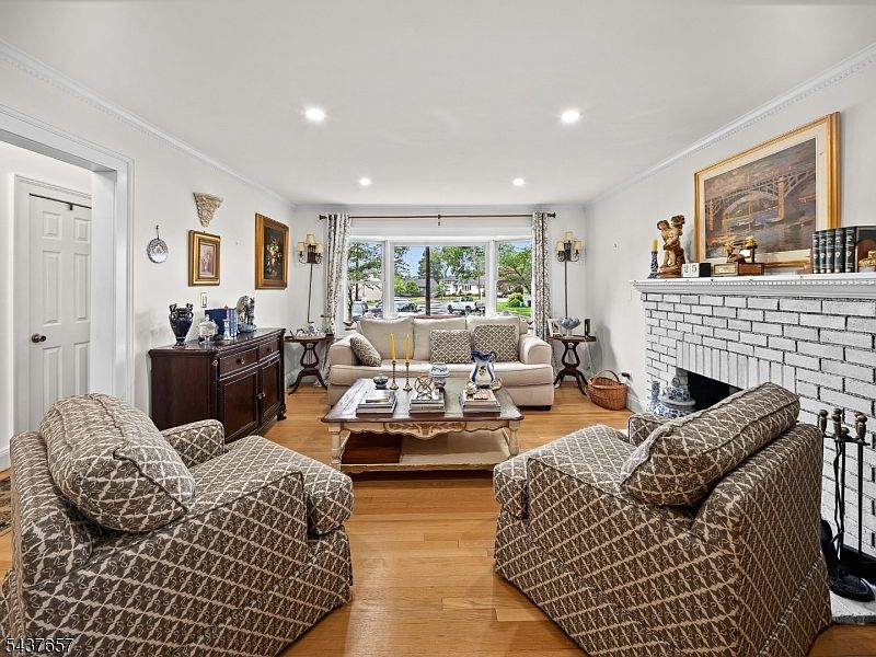 Bright living room with white brick fireplace at 17 Ravine Ct Clifton NJ