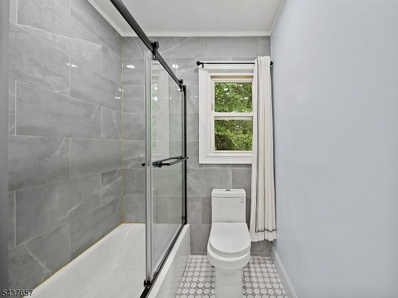 Renovated full bathroom with subway tile and glass shower