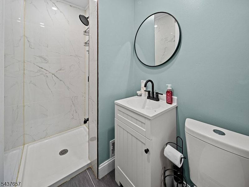 Third full bath with marble-look tile and matte black fixtures