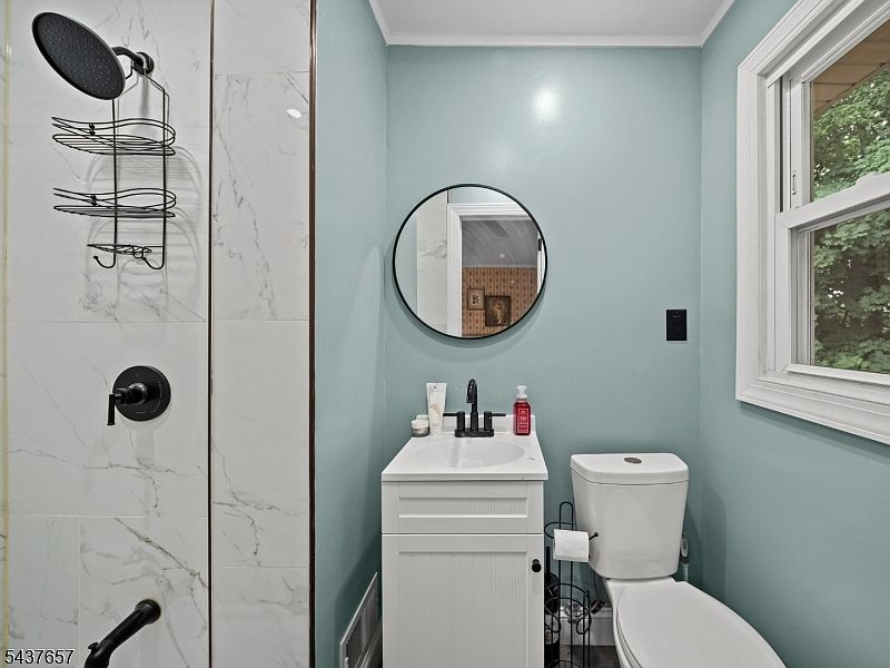 Bathroom with blue walls and marble-look subway tile shower
