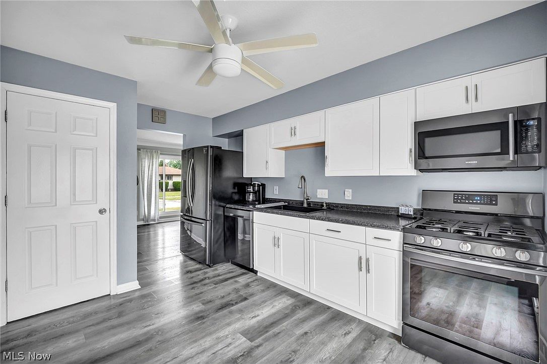 Eat-in kitchen with white cabinets, dark countertops, and natural lighting