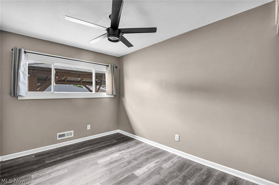 Bedroom with grey LVP flooring and neutral taupe walls