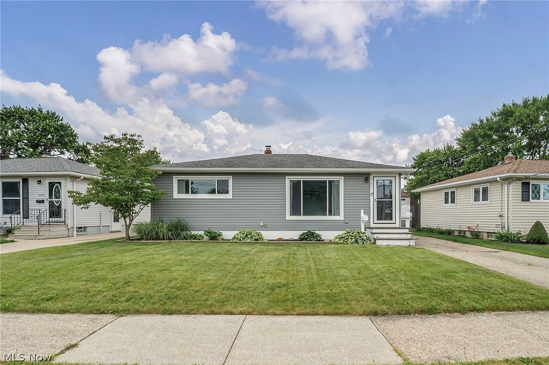 Street view showing the home, front lawn, and concrete sidewalk