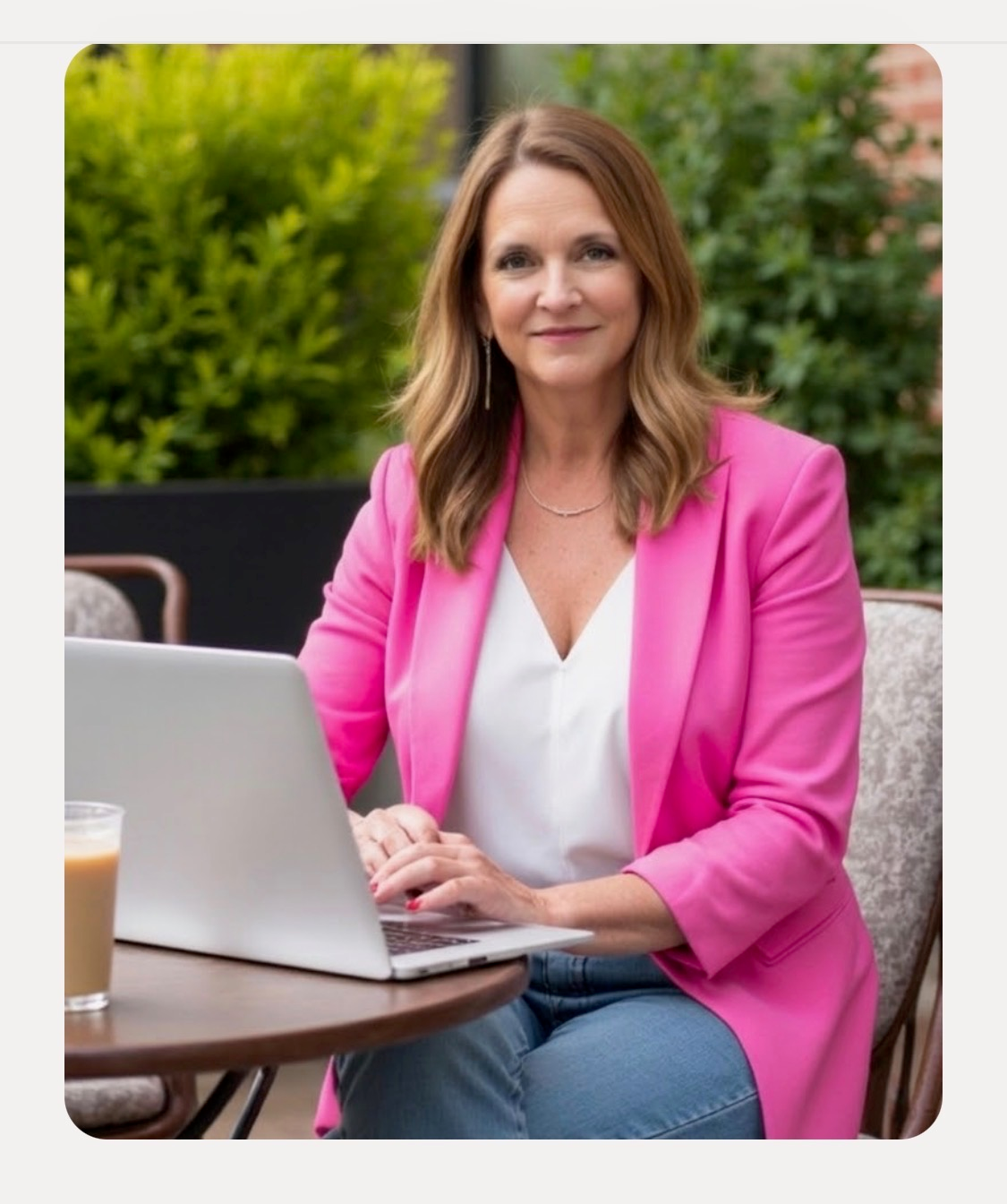 Diane Hibbs, Strategic Real Estate Advisor, in a pink blazer at an outdoor table with a laptop