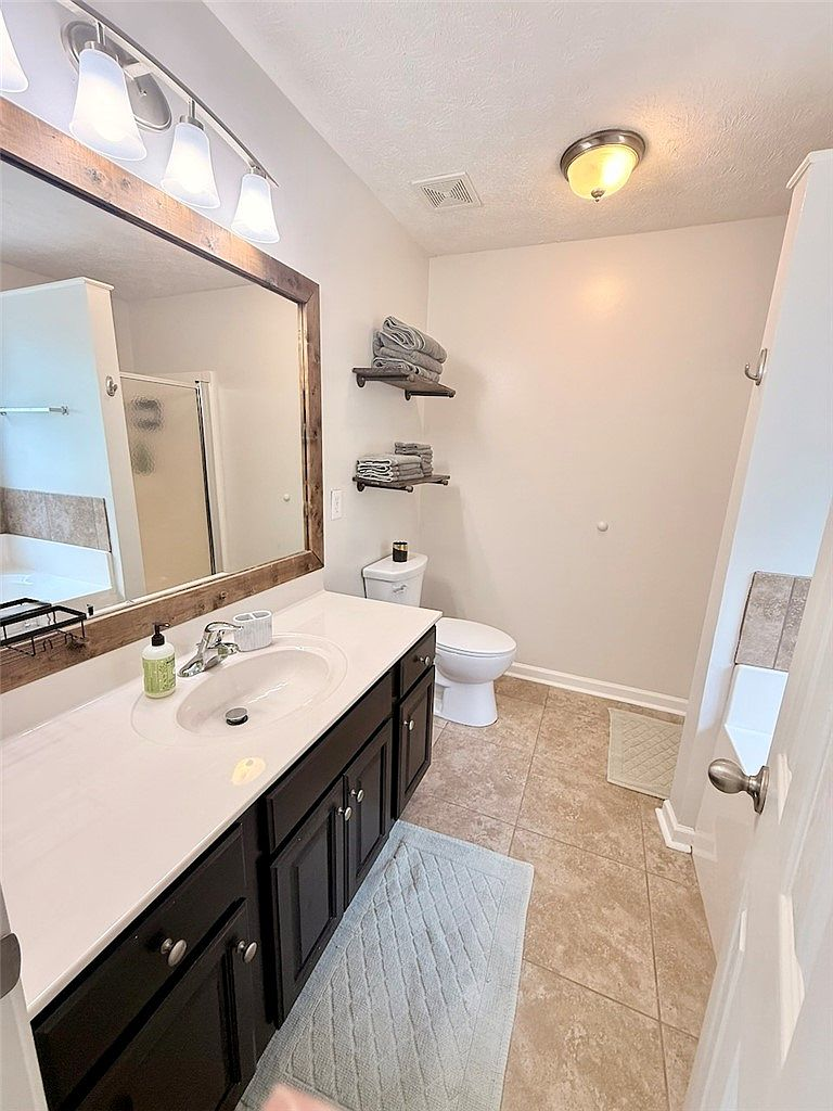 Bathroom with dark wood vanity and tile flooring