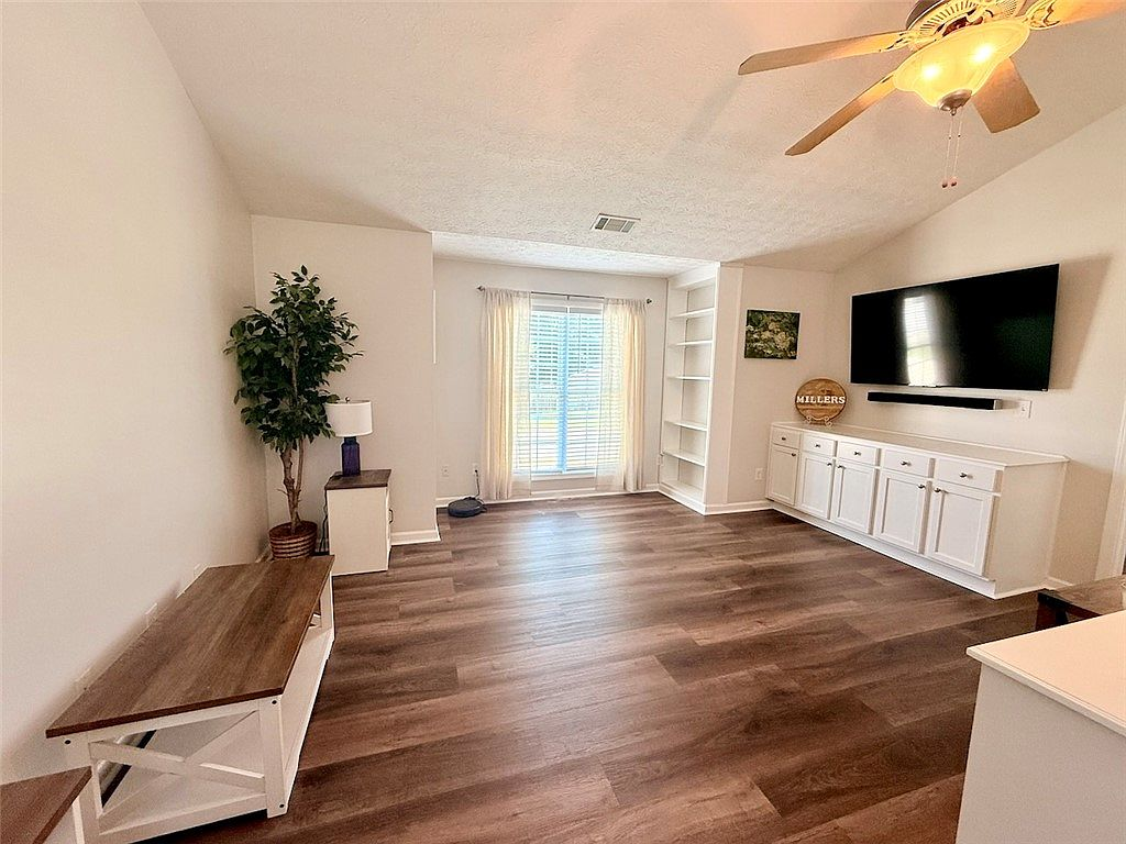Living room with vaulted ceiling and built-in features