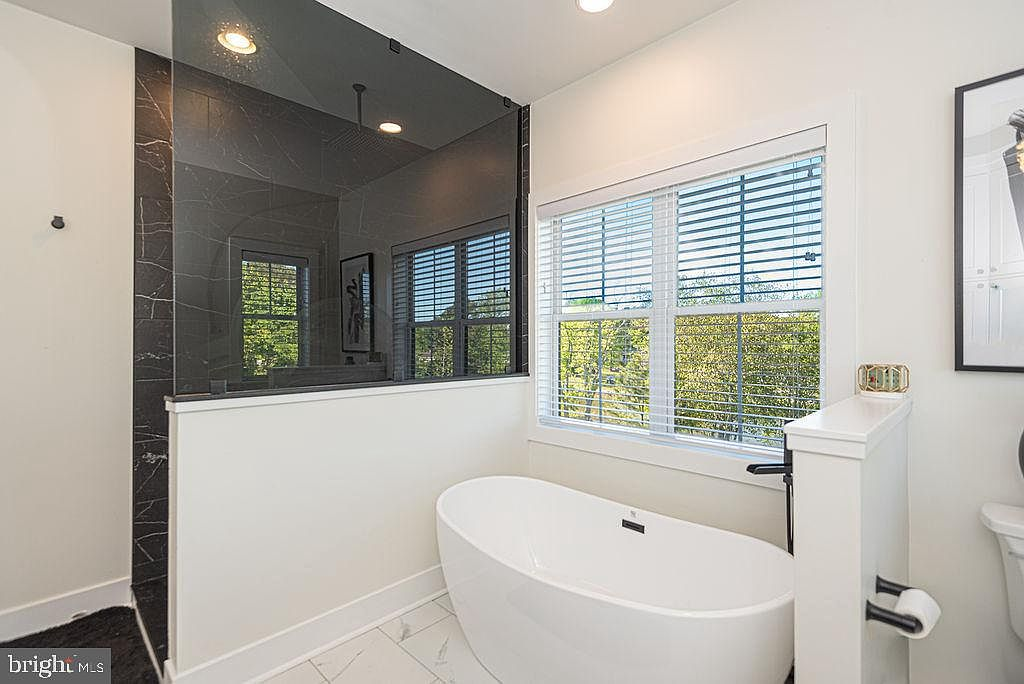 Primary bathroom with freestanding tub and marble-look tile