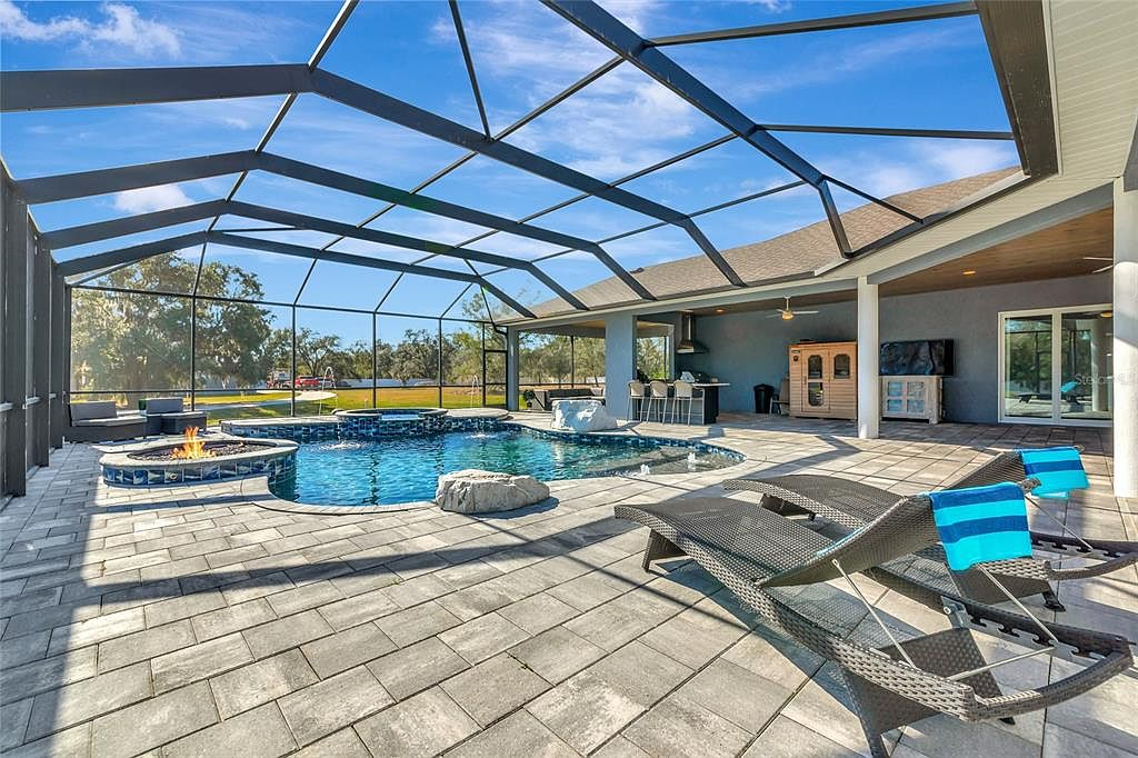 Screened pool and spa with outdoor kitchen, sauna and fire feature