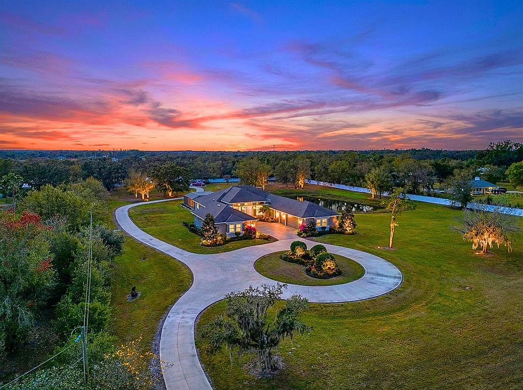 Twilight aerial view of the five-acre estate at 28154 Gopher Hill Rd with landscape lighting