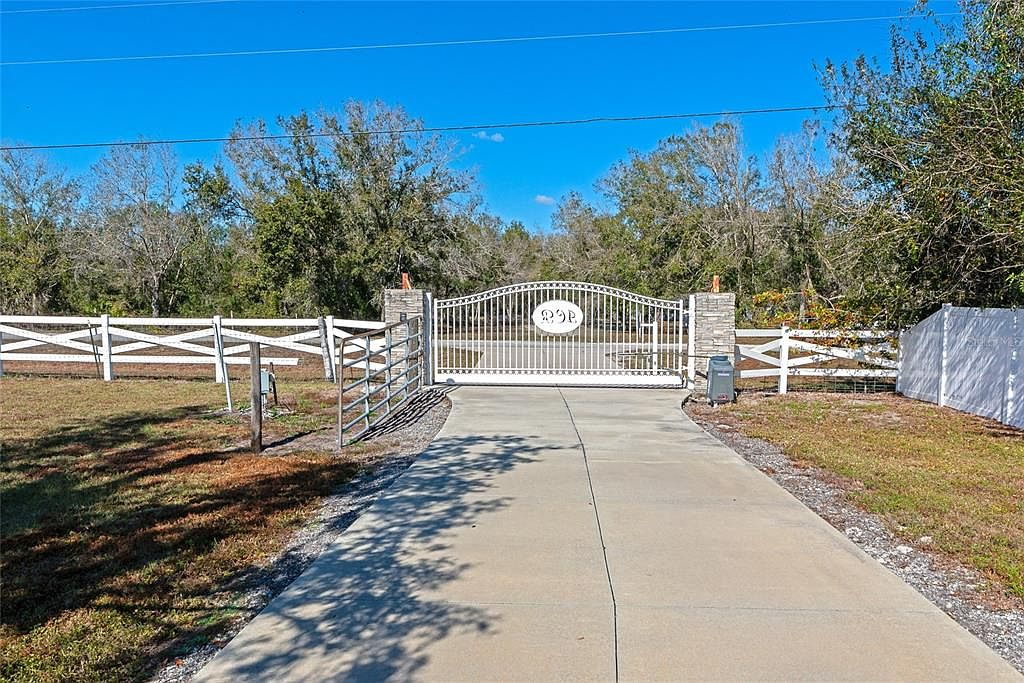 Gated entry with stone pillars and cross-buck fencing