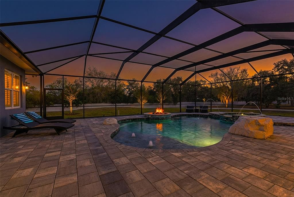 Resort-style pool, spa and fire features at twilight with sunset sky