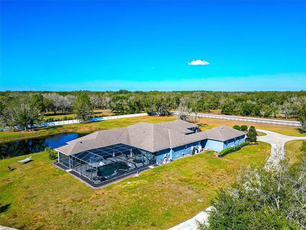Aerial view of the estate's pond, open lawn and mature tree line