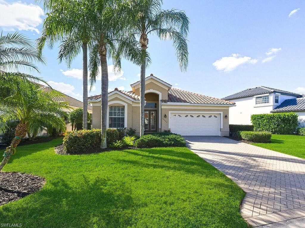 10000 Isola Way exterior — Mediterranean-style home with tile roof and palm trees