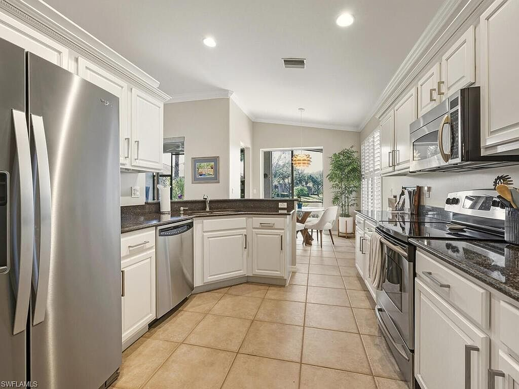 Galley kitchen with white shaker cabinetry and dark granite countertops