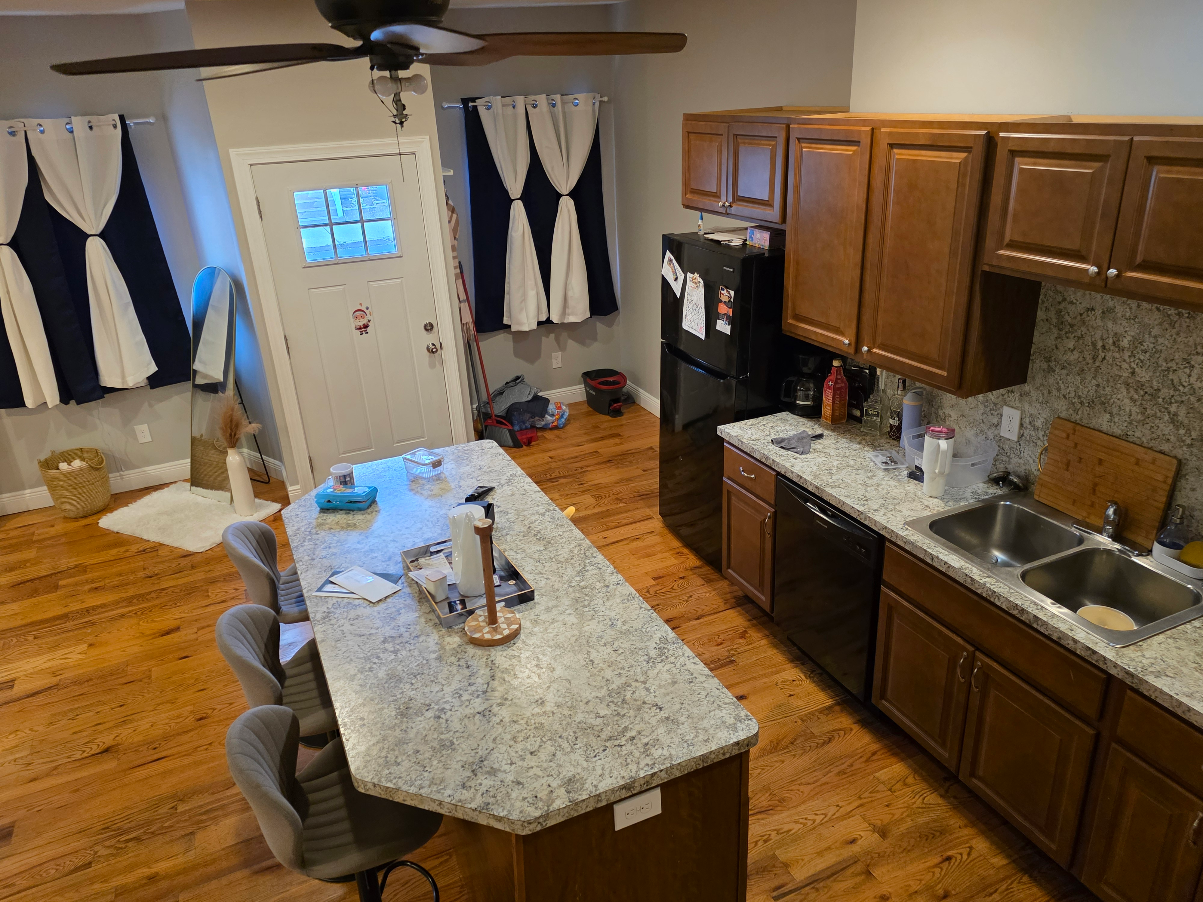 Kitchen layout with island, wood cabinetry, and hardwood floors