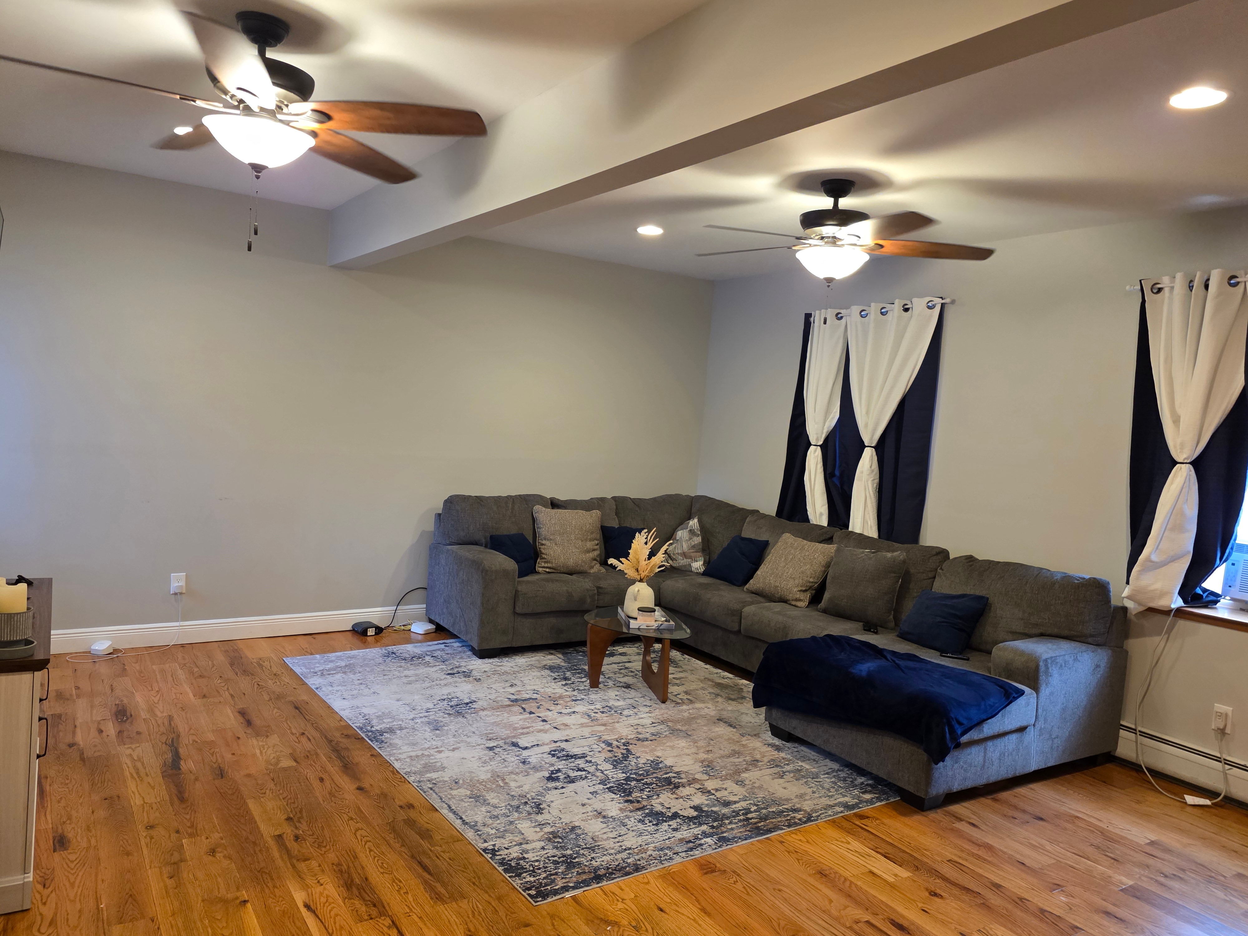 Living room with hardwood floors, recessed lighting, and grey sectional