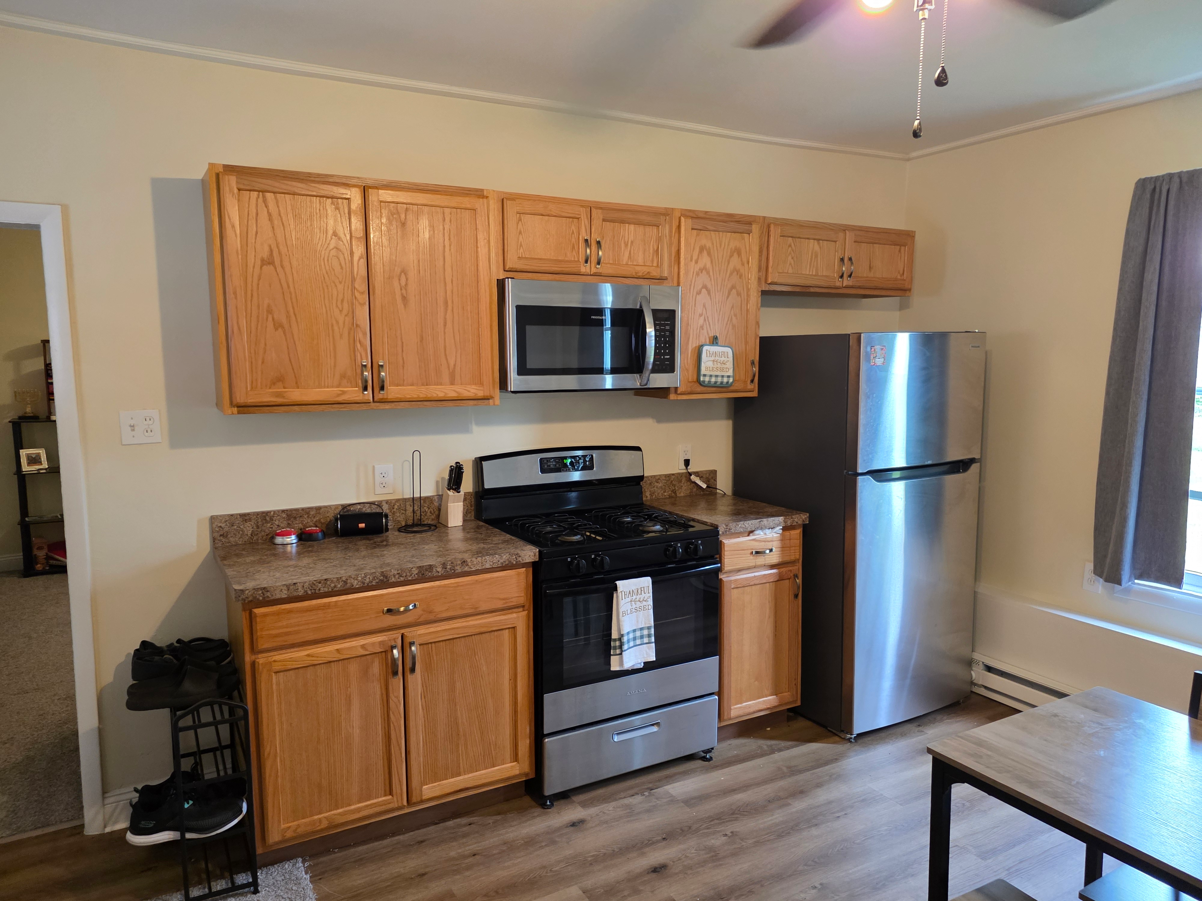 Kitchen perspective view with oak cabinetry and stainless appliances