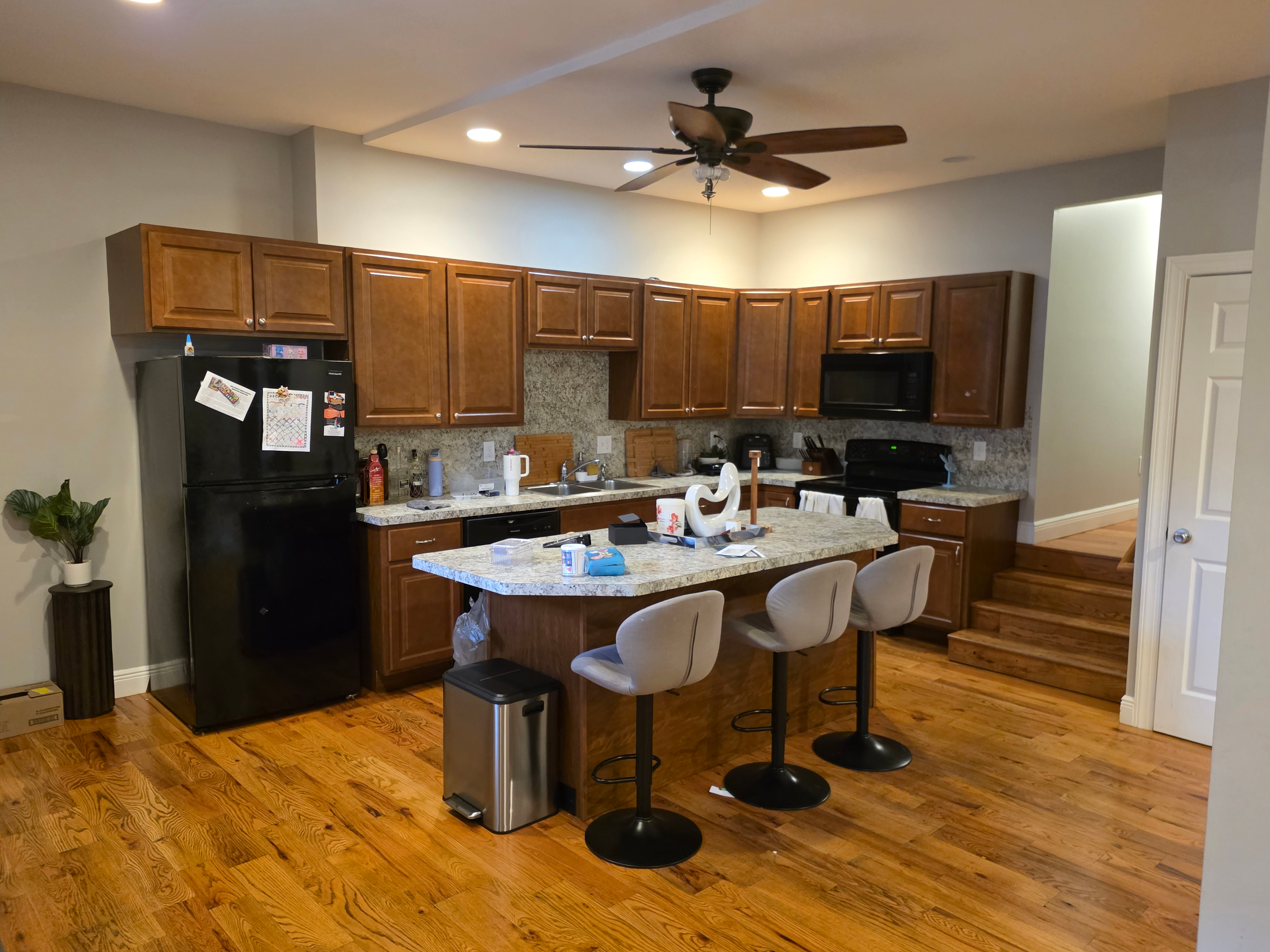Kitchen with oak cabinetry, granite countertops, and stone-tile backsplash