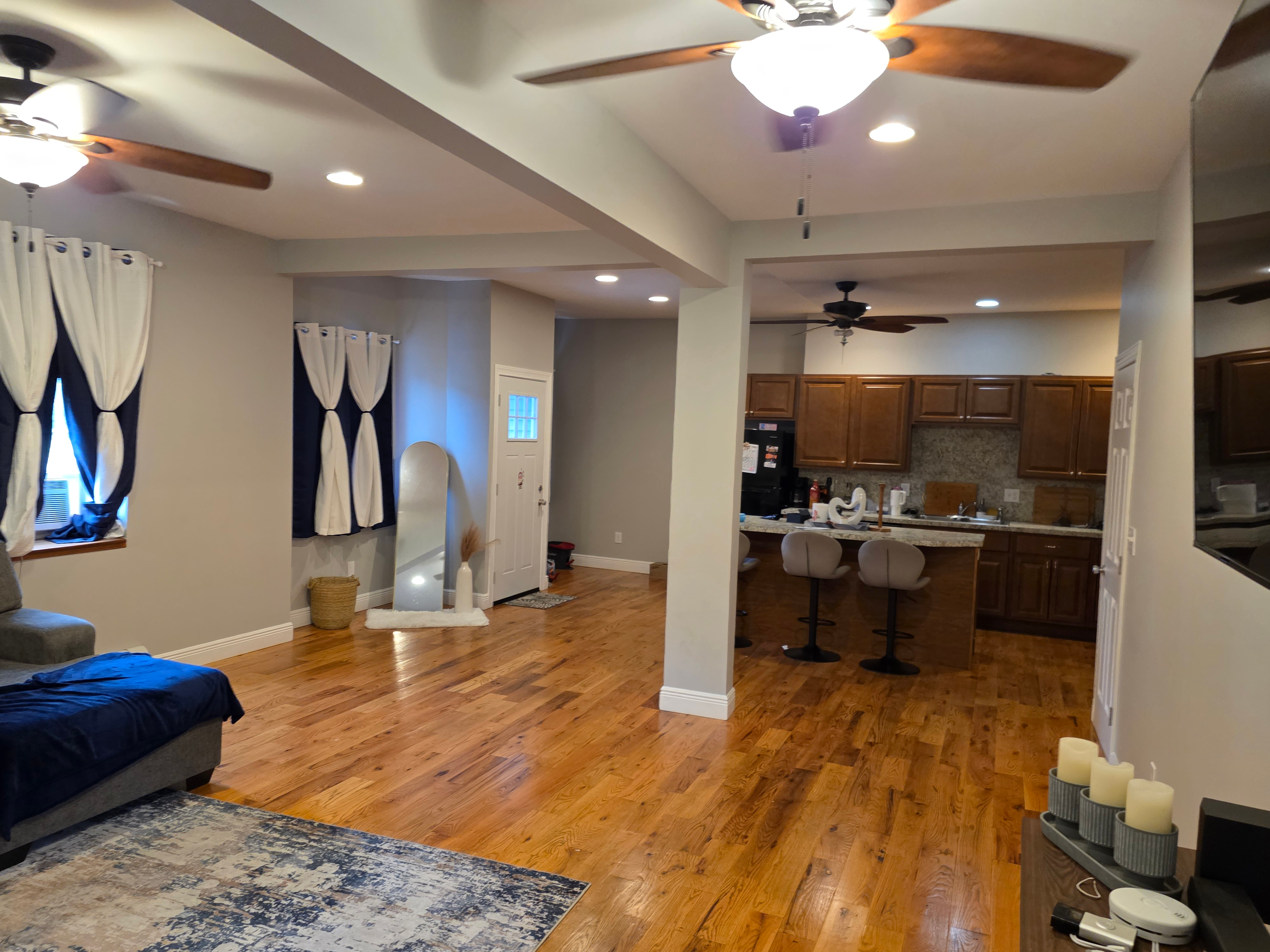 Open-concept living room and kitchen with hardwood floors and granite island