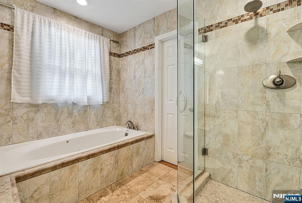 Tiled walk-in shower with glass enclosure